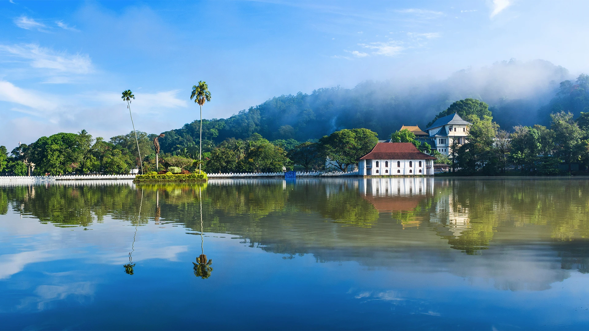 Kandy Lake and the Temple of the Sacred Tooth Relic reflected at sunrise